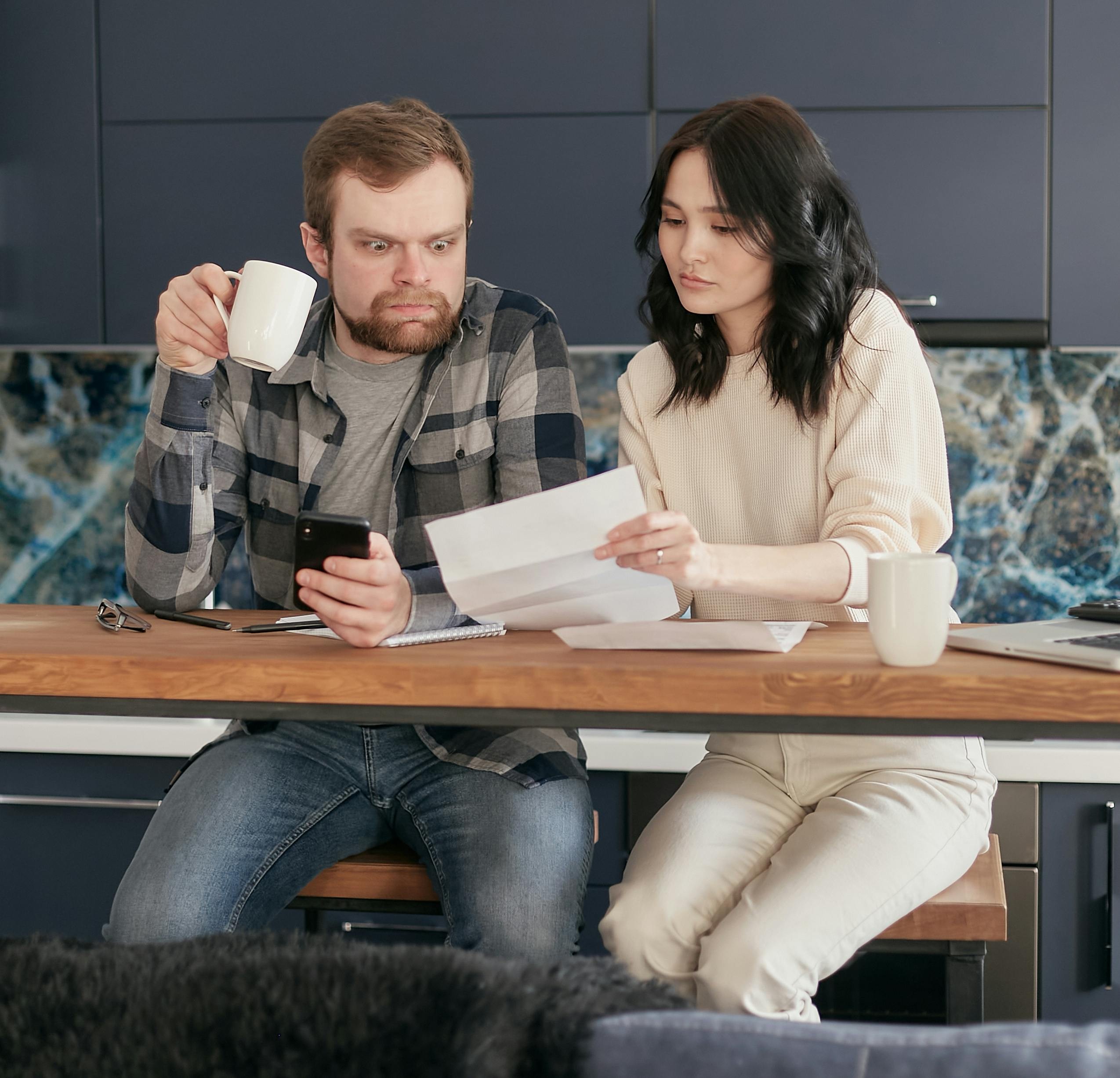 Illustration showing couple discussing joint credit card paperwork at kitchen table