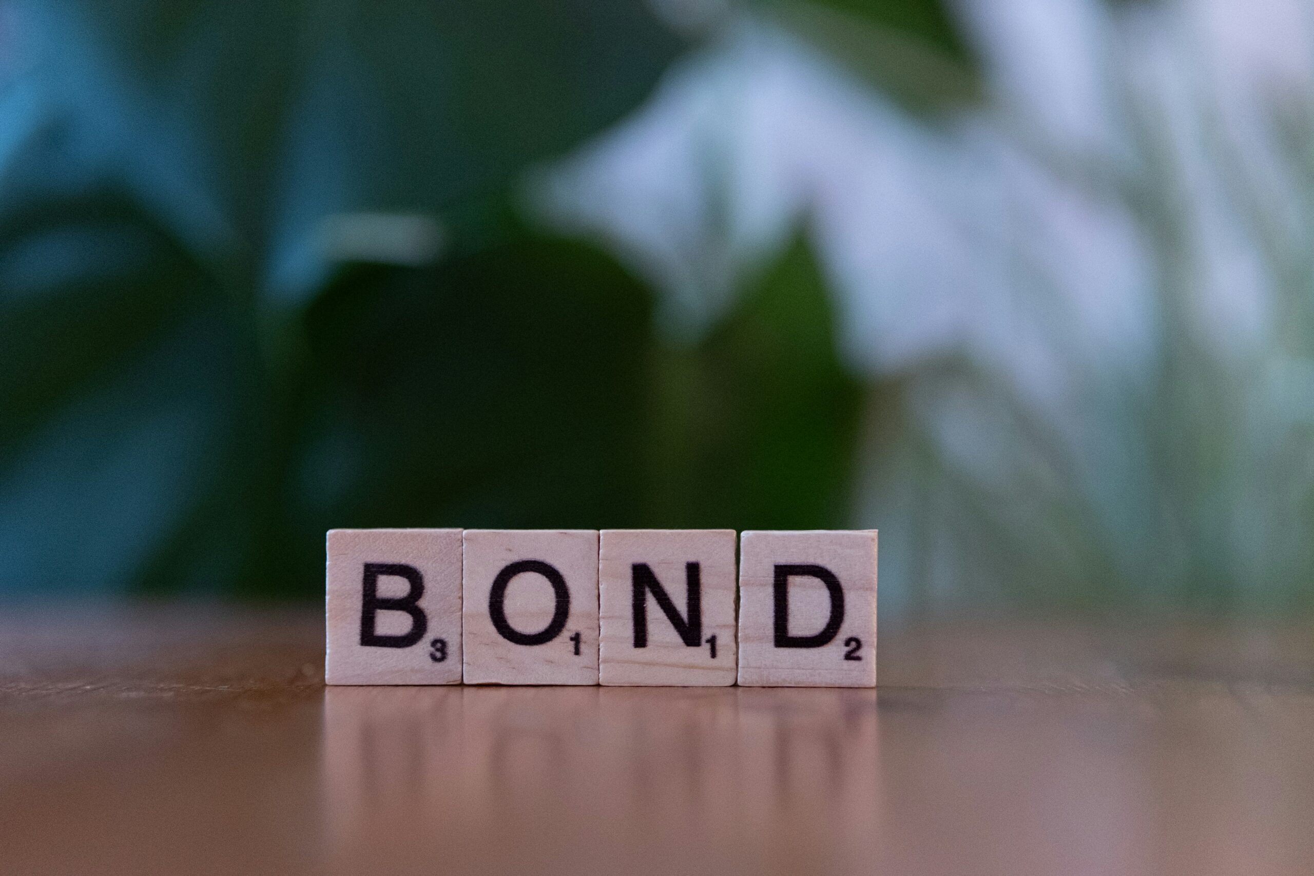 The word bond spelled with scrabble blocks on a table