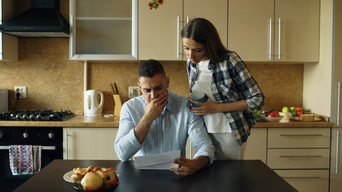 Couple checking joint credit card statements using laptop at home