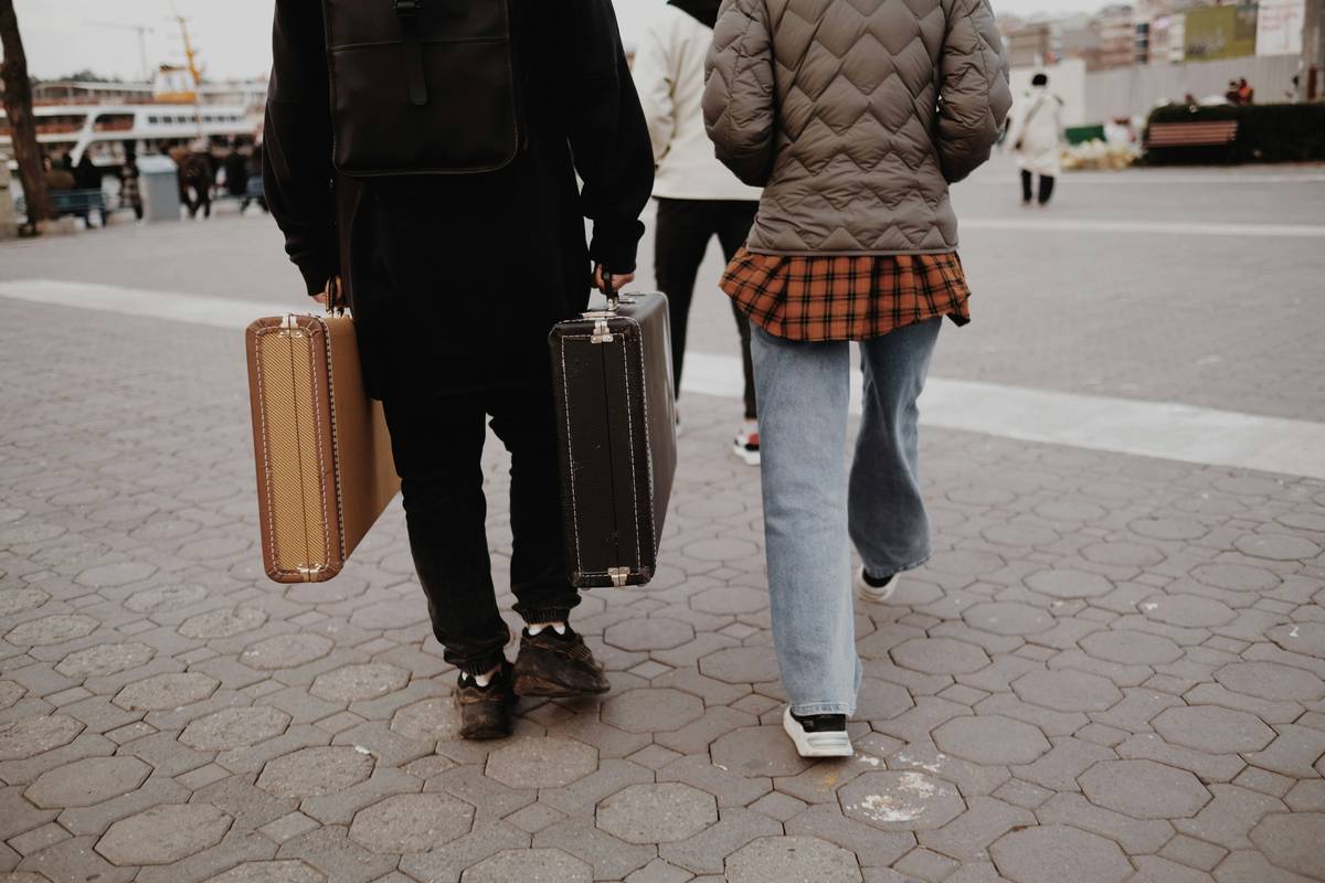 Photo of happy couple posing at an airport with suitcases.
